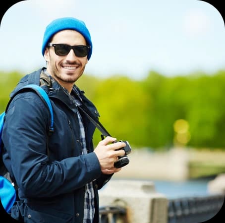 guy holding a camera and smiling